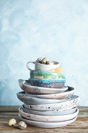 Composition with dinnerware on table against light background, space for text. Interior element
