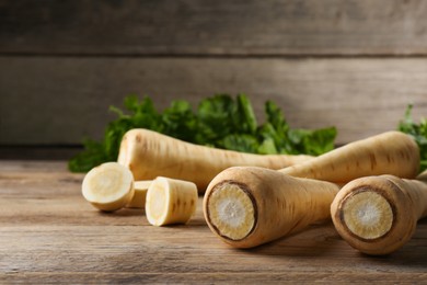 Fresh ripe parsnips on wooden table, closeup. Space for text