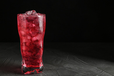 Photo of Tasty cocktail with ice cubes on grey table, closeup. Space for text