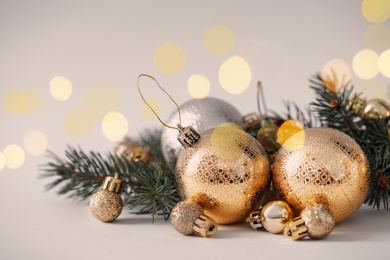 Image of Beautiful Christmas balls and fir branches on light background. Bokeh effect
