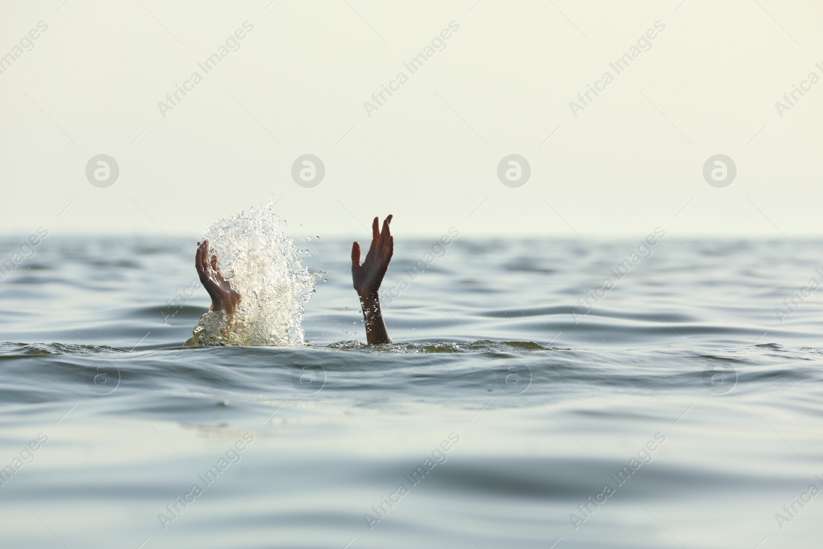 Photo of Drowning woman reaching for help in sea