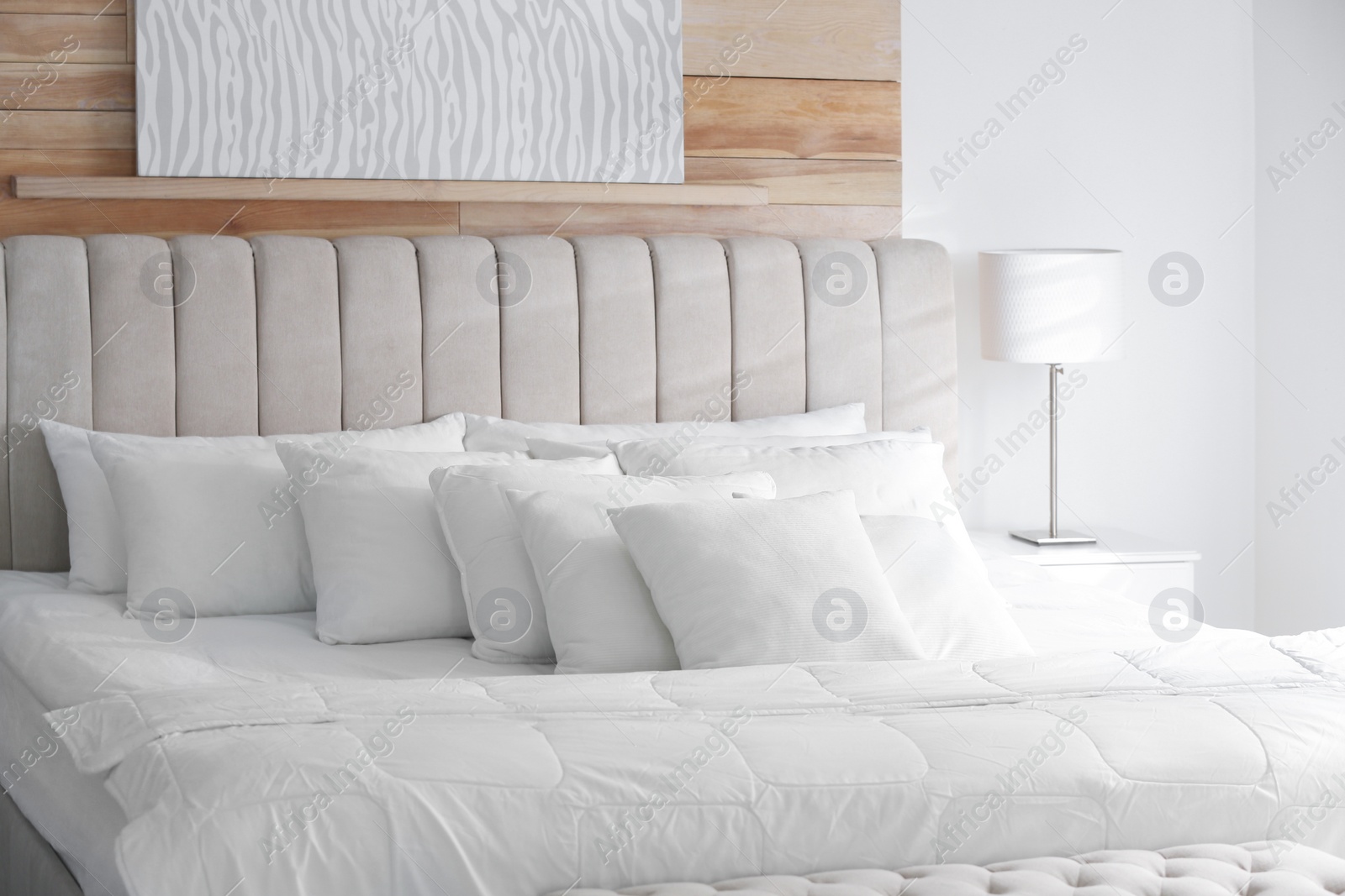 Photo of Comfortable bed with soft white pillows indoors