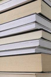 Photo of Stack of many different hardcover books as background, closeup