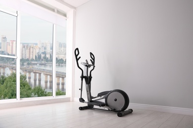 Photo of Elliptical machine cross trainer near window indoors