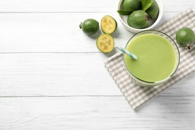 Photo of Fresh feijoa smoothie and fresh fruits on white wooden table, flat lay. Space for text