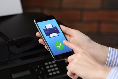 Photo of Man using printer management application on mobile phone indoors, closeup. Image on device screen.