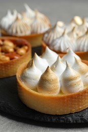 Photo of Different tartlets on grey table, closeup. Delicious dessert