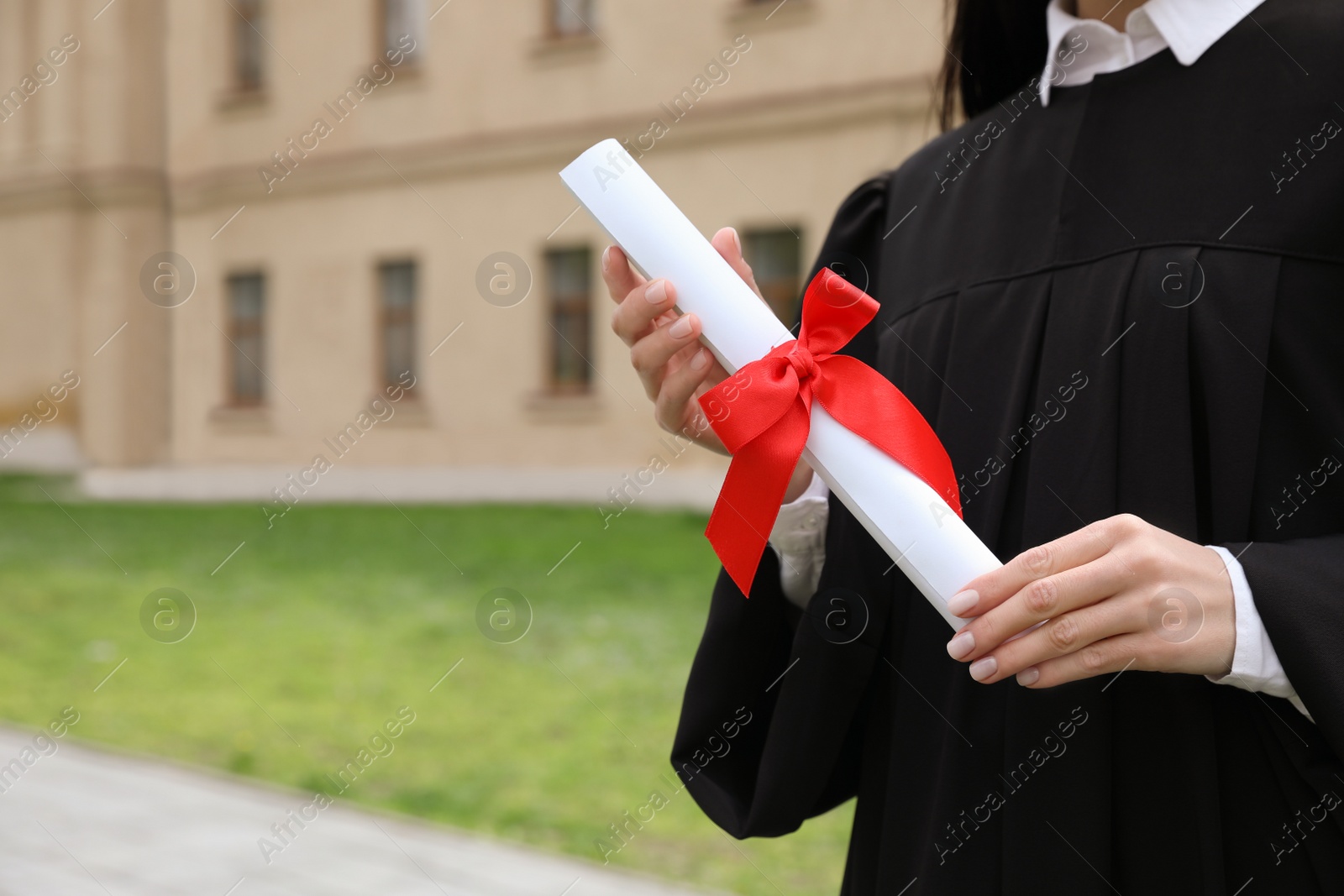 Photo of Student with diploma after graduation ceremony outdoors, closeup. Space for text