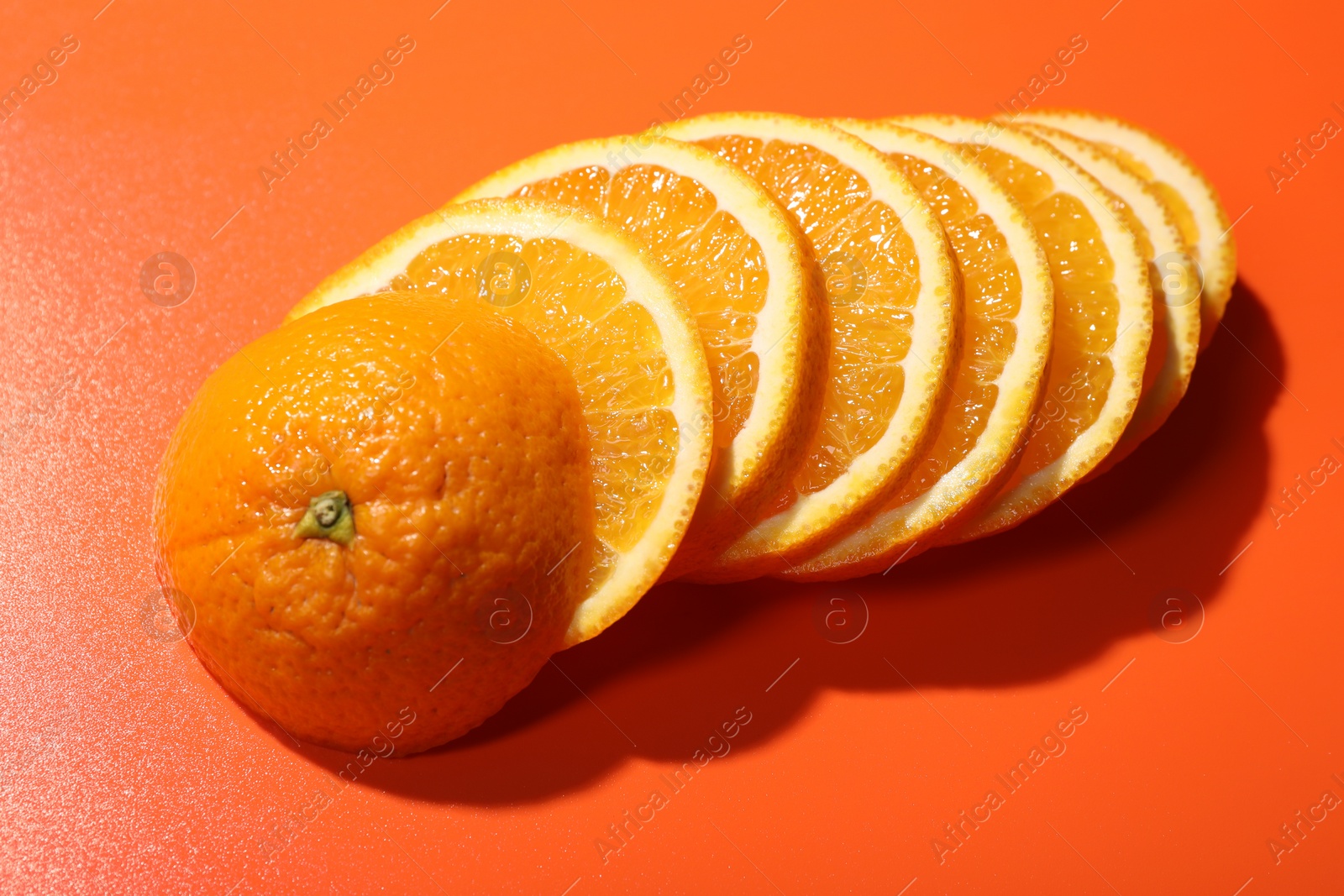 Photo of Slices of juicy orange on terracotta background