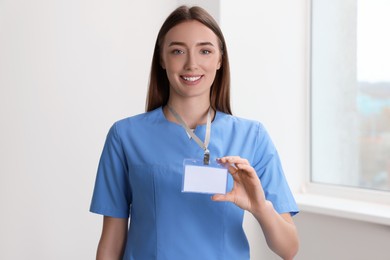 Happy doctor with blank badge in hospital