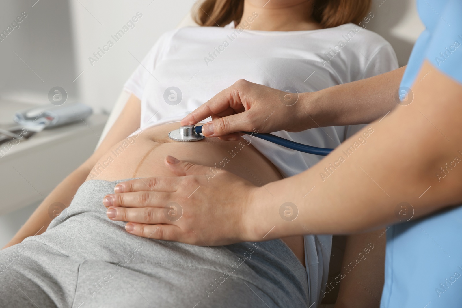 Photo of Doctor examining pregnant woman in hospital, closeup