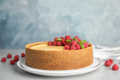 Photo of Dessert plate with delicious raspberry cake on table against blue background. Space for text