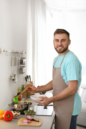 Photo of Young man pouring delicious soup into bowl at home