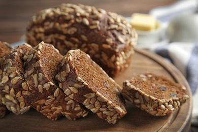 Photo of Tasty rye bread on wooden board, closeup