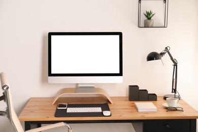 Stylish workplace interior with modern computer on table. Mockup for design