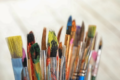 Photo of Different paint brushes on light background, closeup