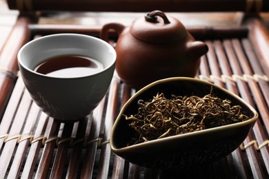Aromatic Dianhong tea on wooden tray, closeup. Traditional ceremony