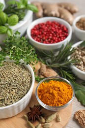 Different herbs and spices on wooden table, closeup