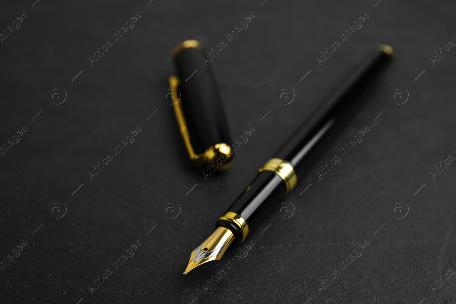 Photo of Beautiful fountain pen with ornate nib on black table, closeup