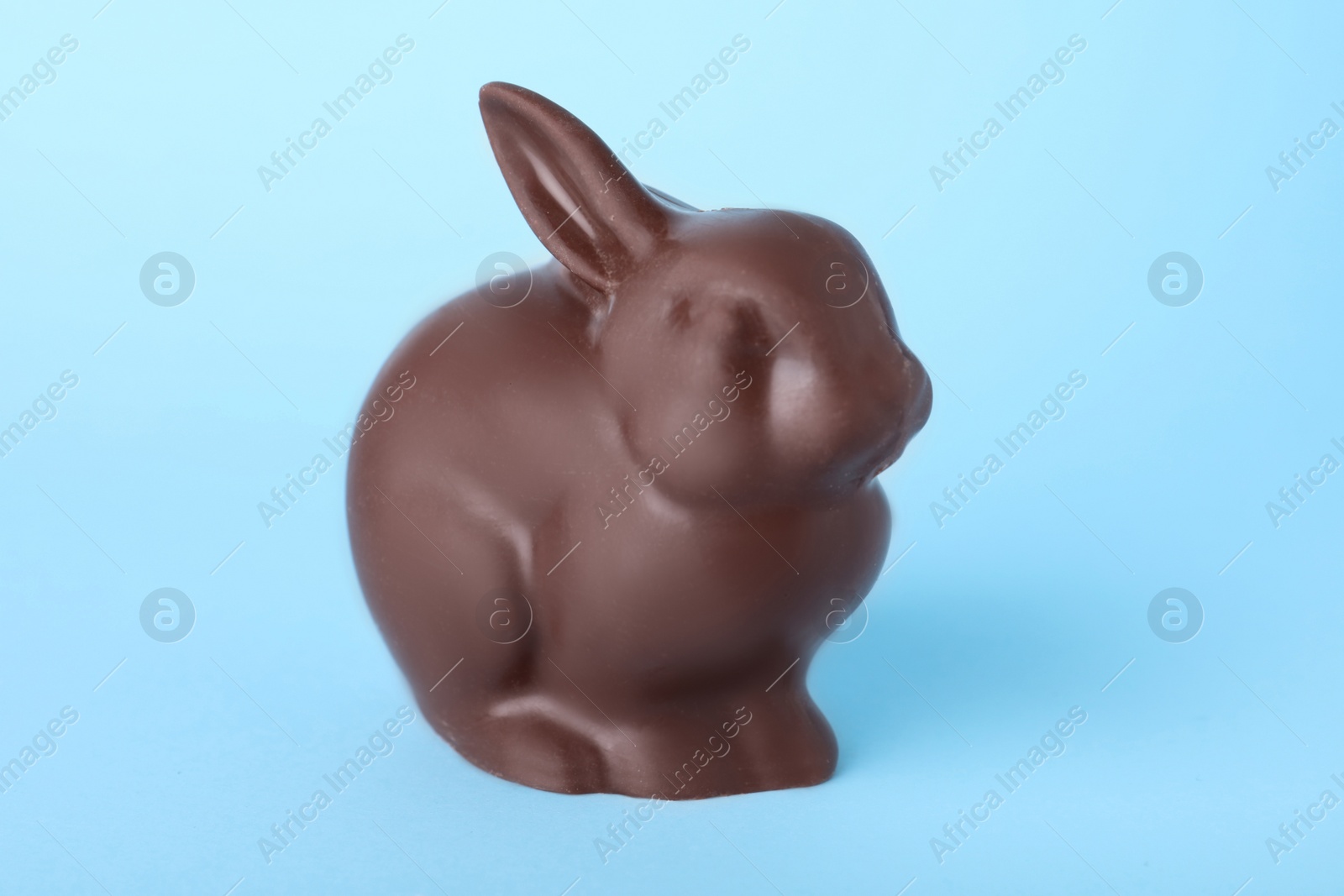 Photo of Chocolate bunny on light blue background. Easter celebration