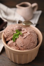 Photo of Bowl of tasty chocolate ice cream on table, closeup