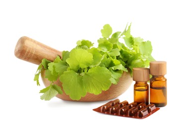 Photo of Mortar with fresh green celandine, extracts and pills on white background