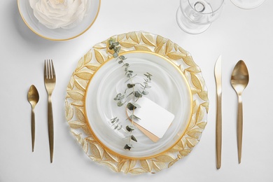 Elegant table setting on light background, top view