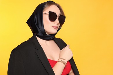 Photo of Young woman with lip piercing and sunglasses on yellow background. Space for text