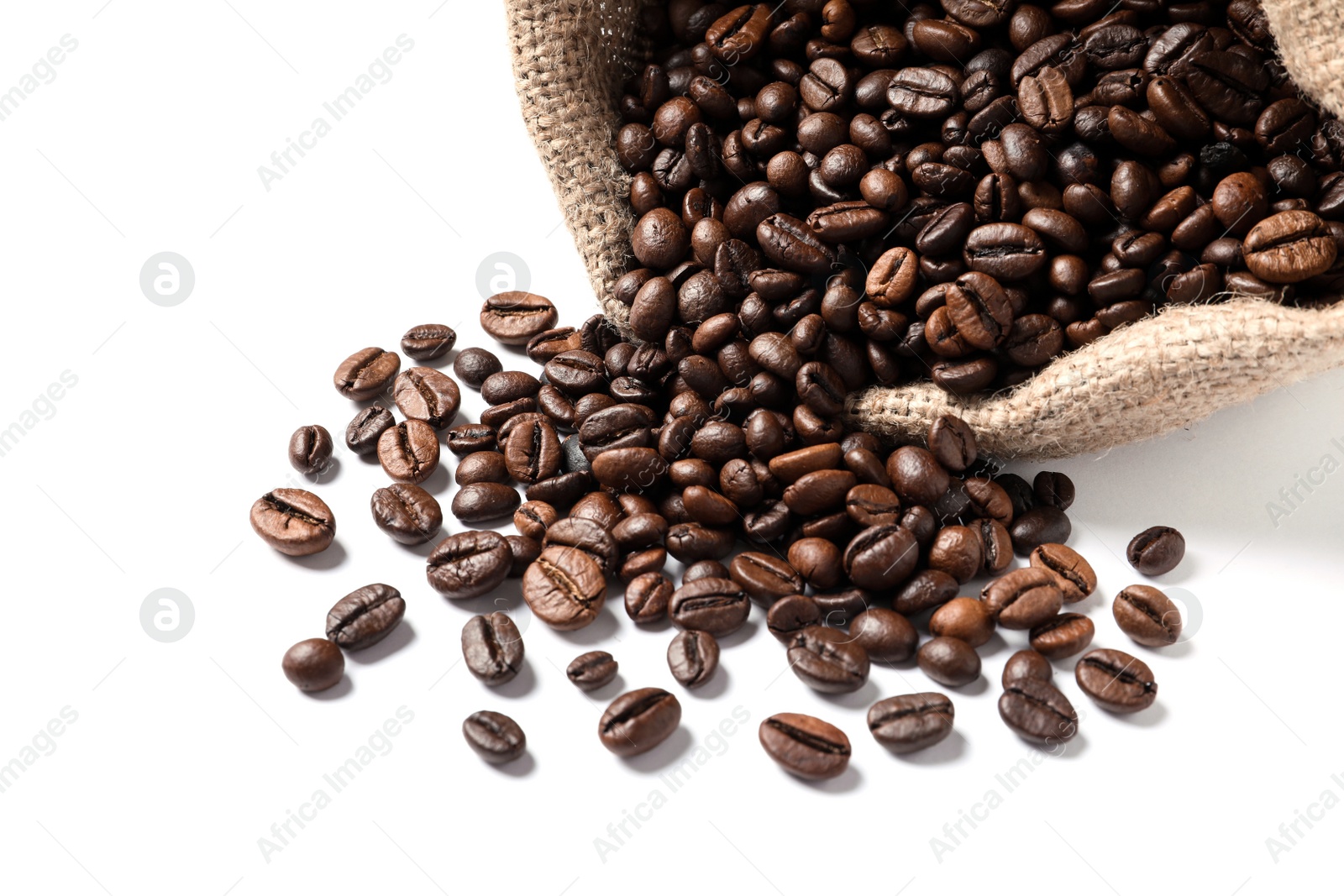 Photo of Overturned bag with roasted coffee beans on white background, closeup