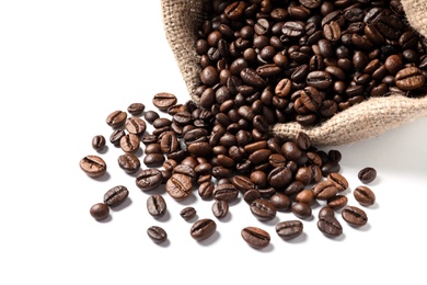 Overturned bag with roasted coffee beans on white background, closeup