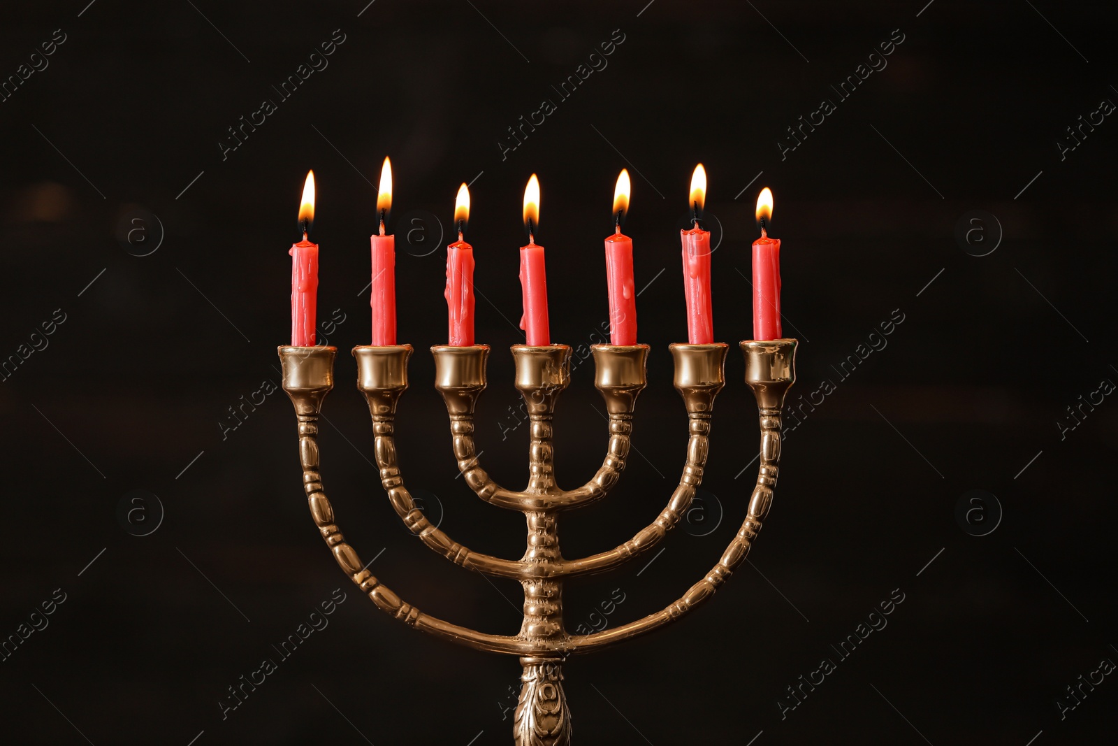 Photo of Golden menorah with burning candles on blurred background