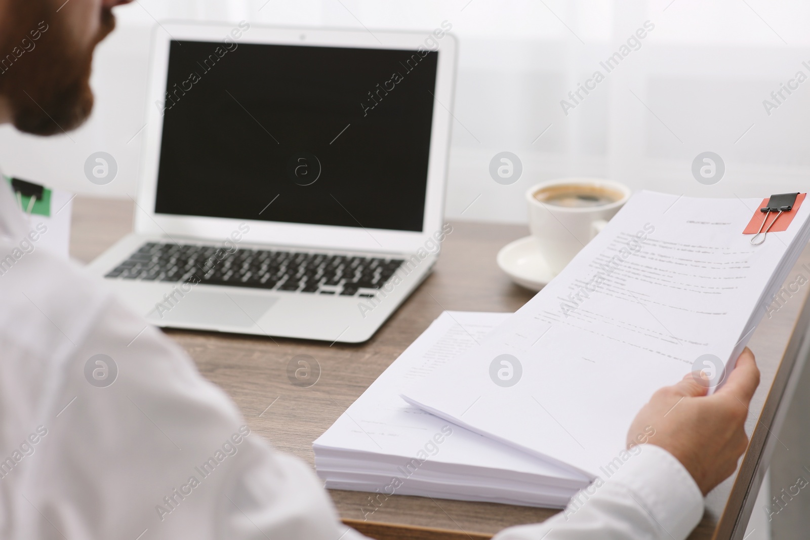 Photo of Businessman working with documents at table in office, closeup