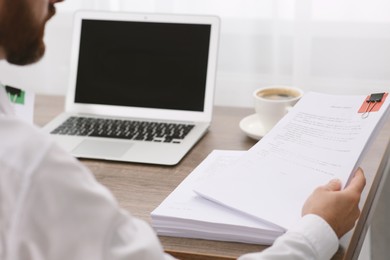 Businessman working with documents at table in office, closeup