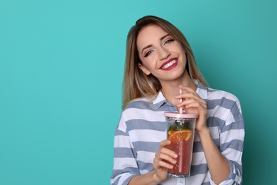 Photo of Young woman with tasty lemonade on color background. Natural detox drink