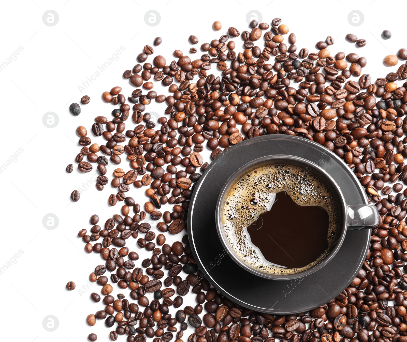 Photo of Roasted coffee beans and cup of hot beverage on white background, top view