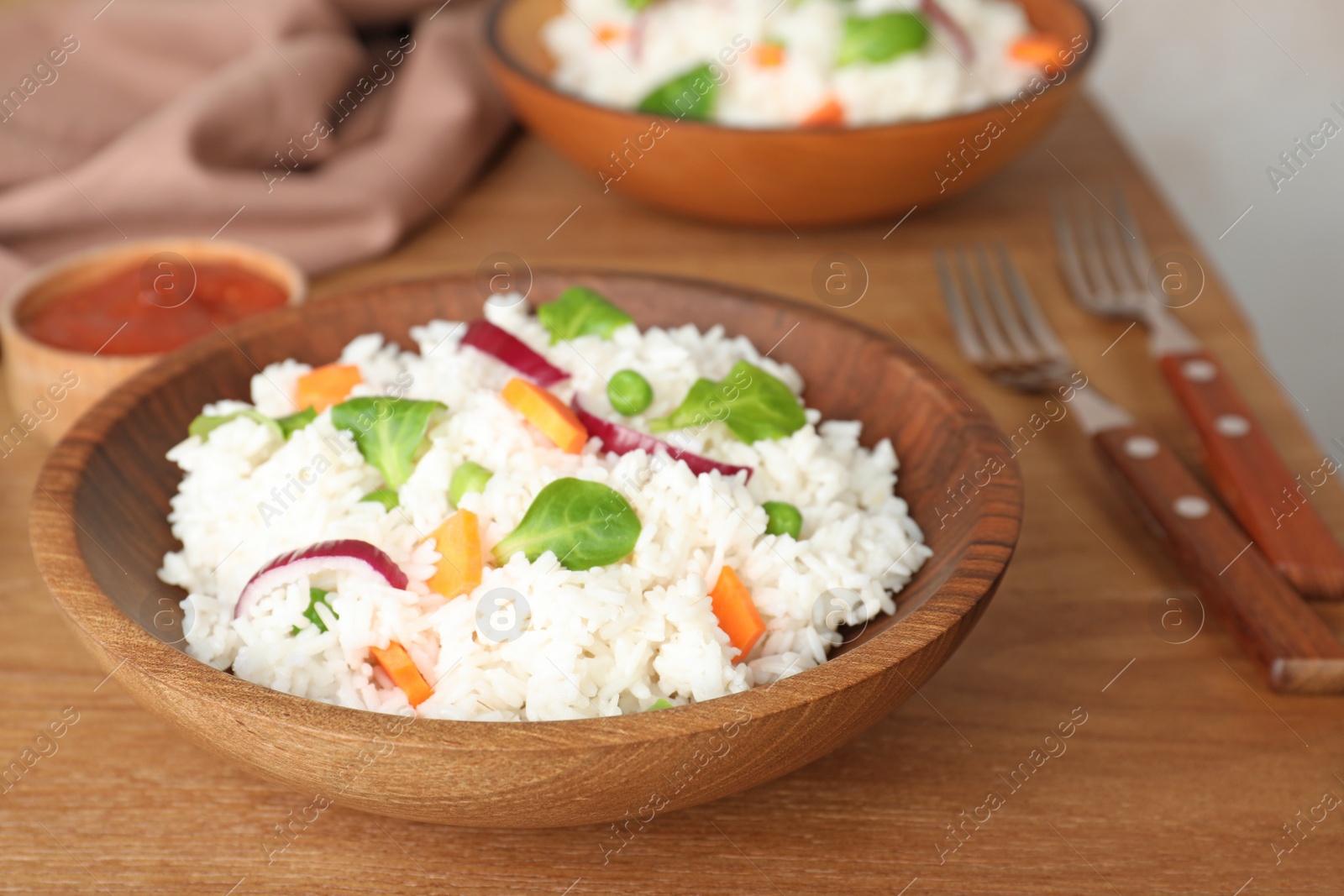 Photo of Bowl of boiled rice with vegetables on table. Space for text