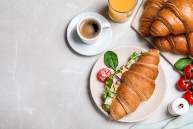 Photo of Flat lay composition with tasty croissant sandwich on light grey marble table, space for text