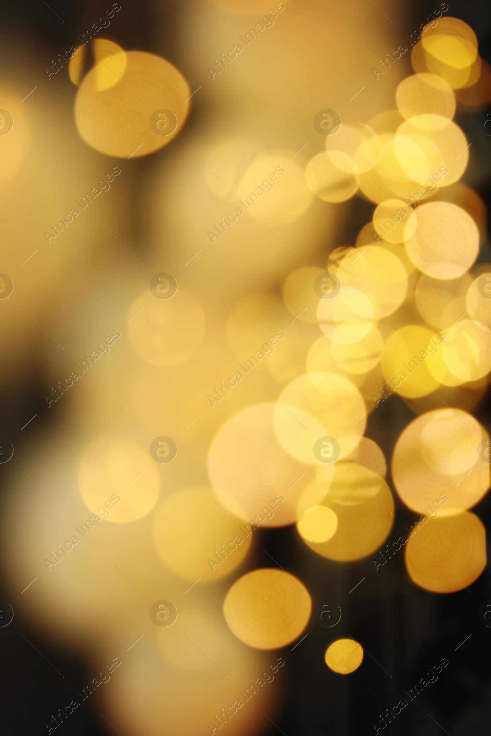 Photo of Blurred view of gold lights on dark background. Bokeh effect