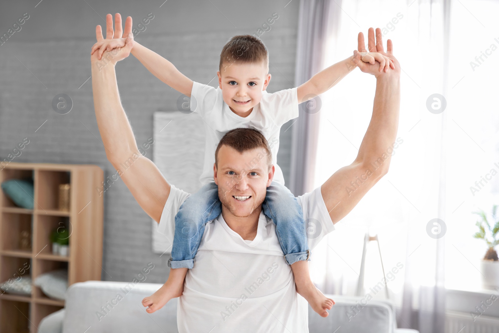 Photo of Happy dad playing with his son at home. Father's day celebration