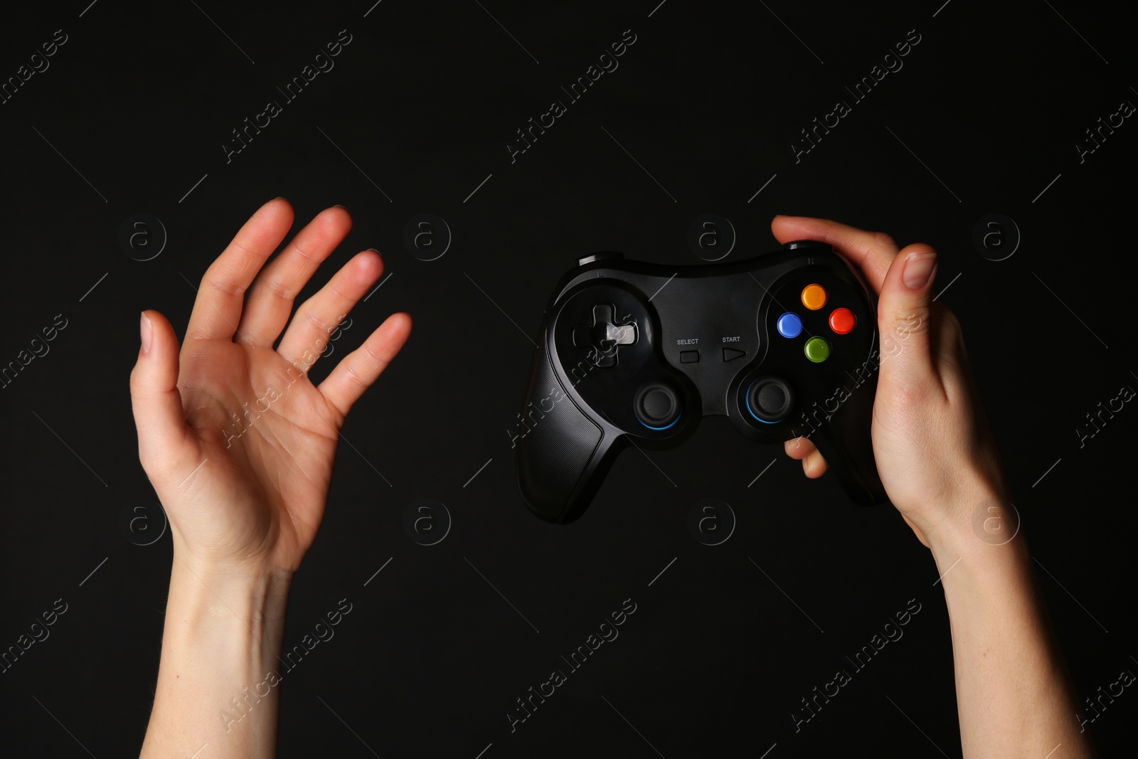 Photo of Woman with game controller on black background, closeup