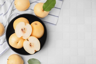 Delicious apple pears on white tiled table, flat lay. Space for text