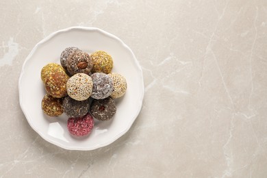 Different delicious vegan candy balls on light grey marble table, top view. Space for text