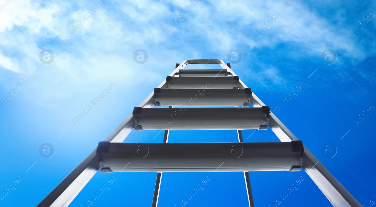 Image of Metal stepladder against blue sky with clouds, low angle view. Banner design 