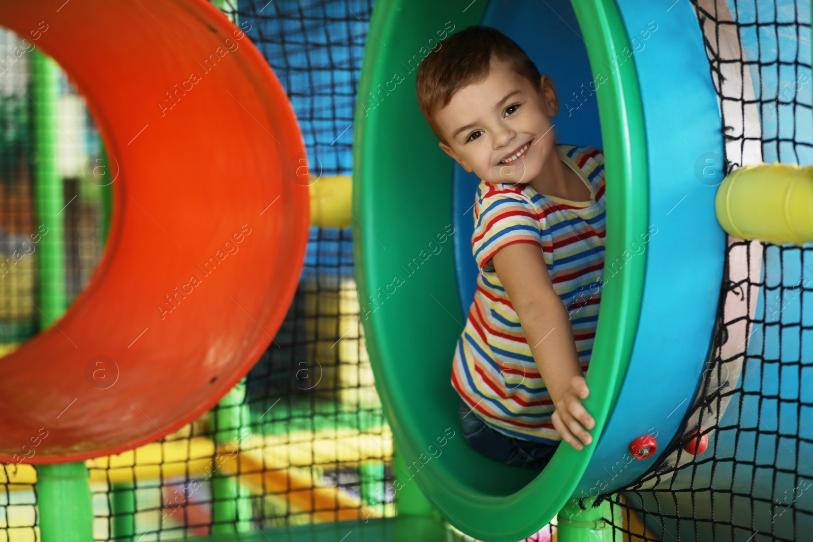 Photo of Cute little child playing at indoor amusement park