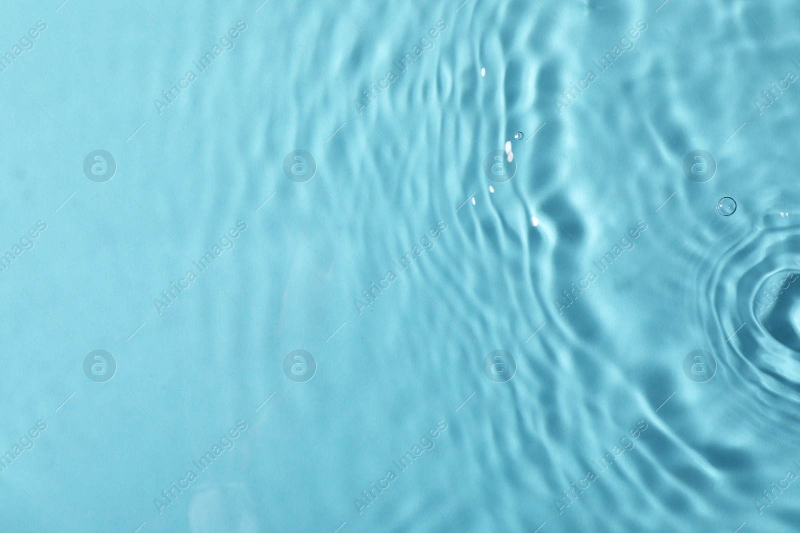 Photo of Closeup view of water with rippled surface on light blue background