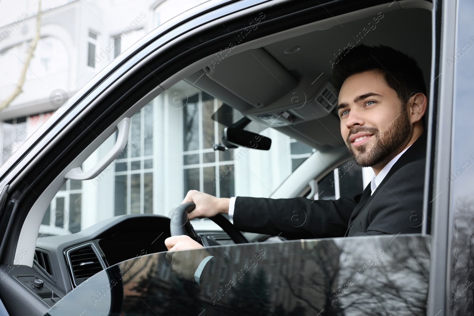 Photo of Handsome young man driving his modern car