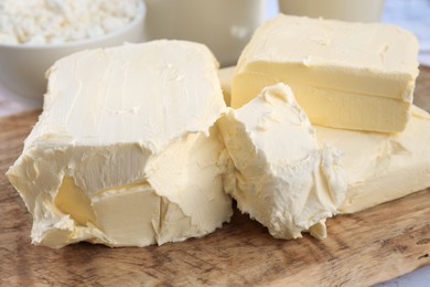 Photo of Tasty homemade butter and dairy products on wooden board, closeup
