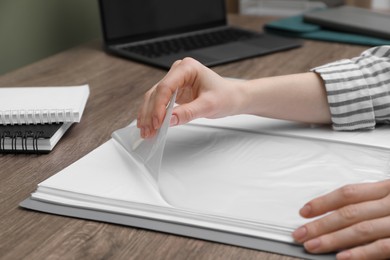 Woman with punched pockets at wooden table, closeup