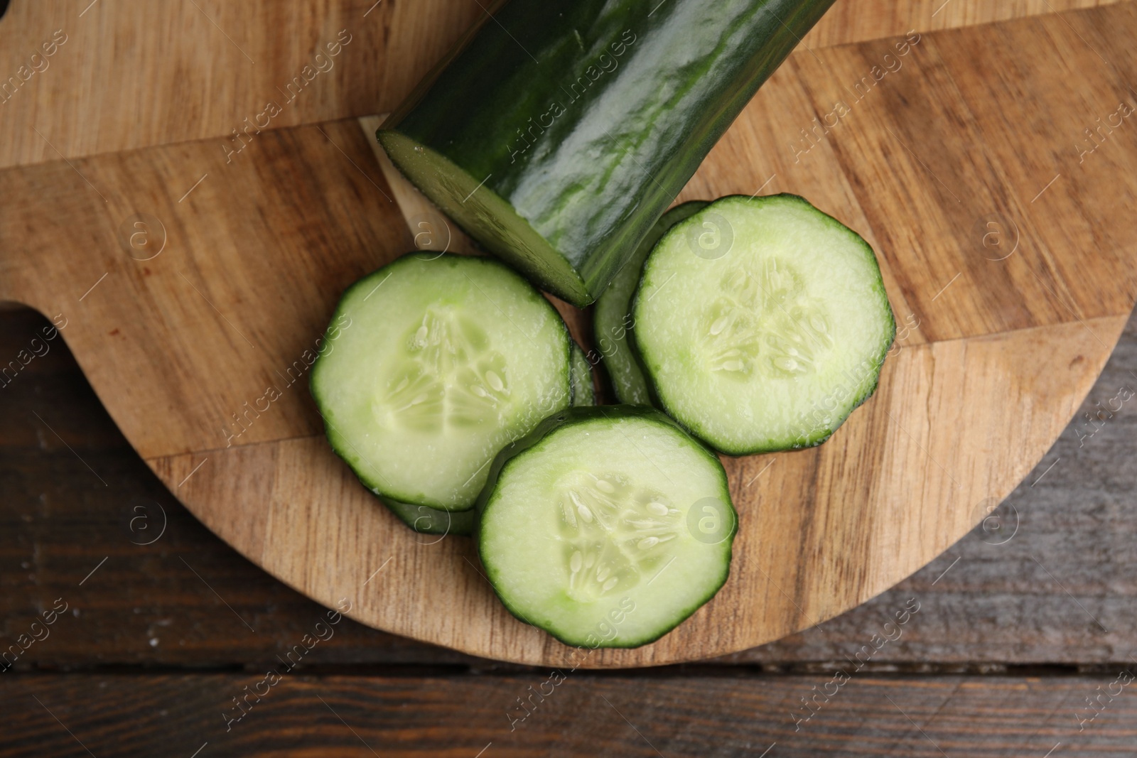 Photo of Fresh cut cucumber on wooden table, top view