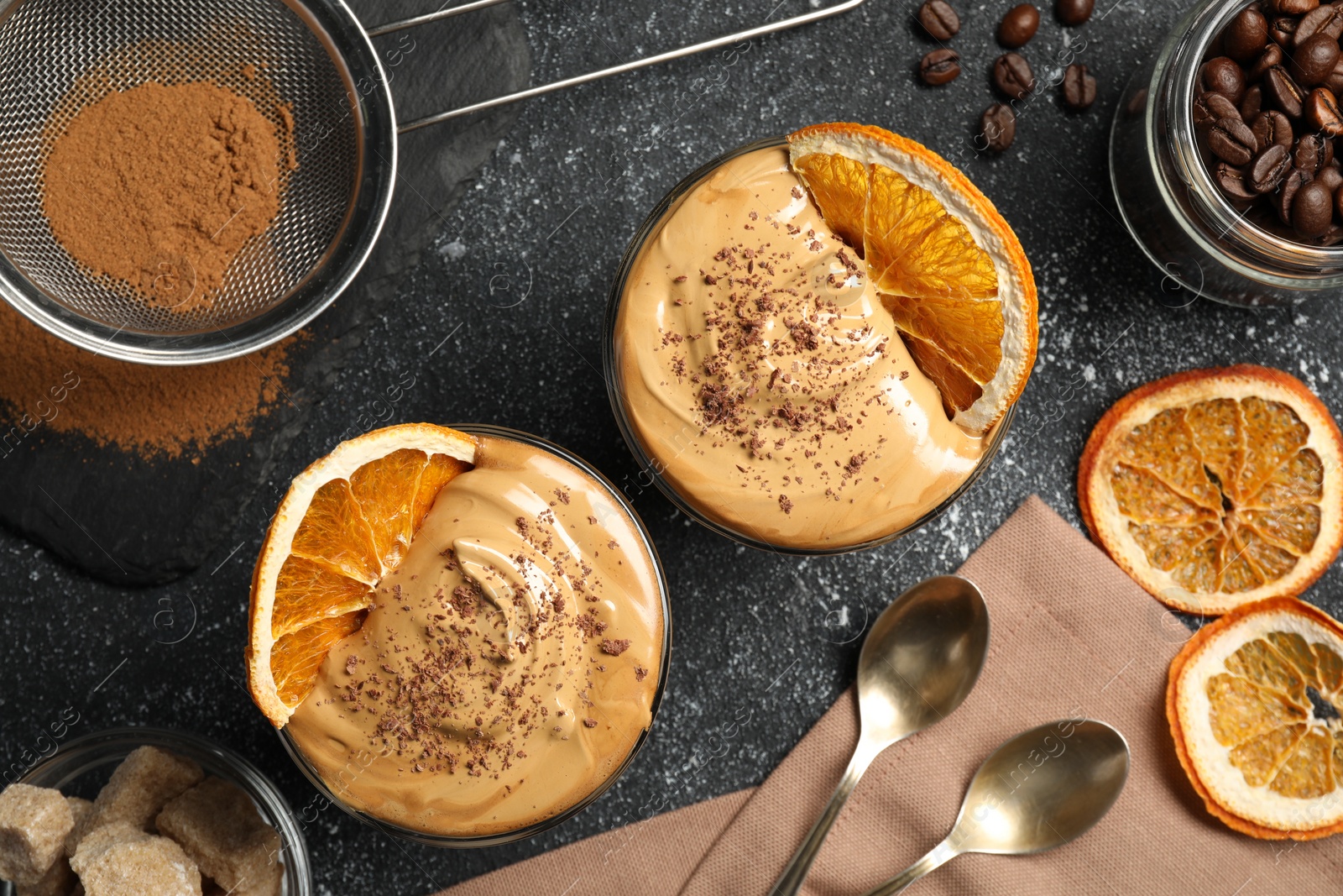 Photo of Glasses of delicious dalgona coffee with ingredients on grey textured table, flat lay